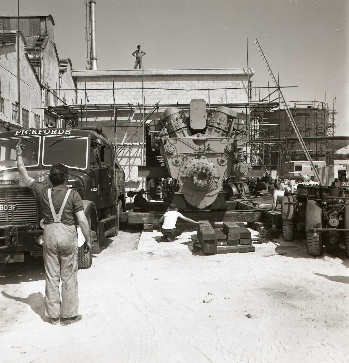 A Pickfords Scammell inching the load through the open gable of the building.